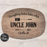 everything tastes better when uncle grills it serving platter on brown wood with fork and spatula